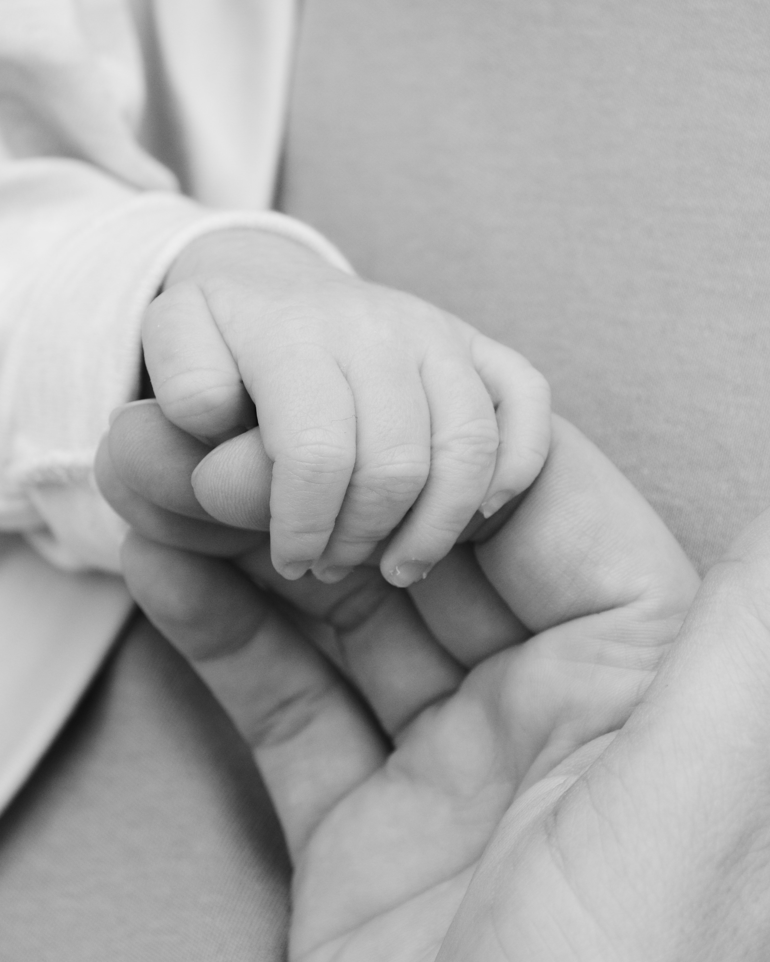 Baby und Mama halten Hände